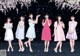 A group of young women standing in front of a black background.