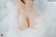A naked woman is sitting in a bathtub filled with foam.