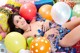 A woman laying on top of a pile of balloons.