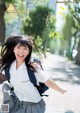 A young woman in a school uniform is running down the street.