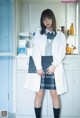 A woman in a lab coat and skirt standing in a room.