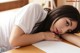 A woman laying on top of a wooden table.