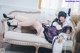 A woman in a maid outfit is sitting on a couch.